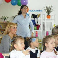 Dzieci słuchające odczytu na otwarciu przedszkola Wesoły Uśmiech